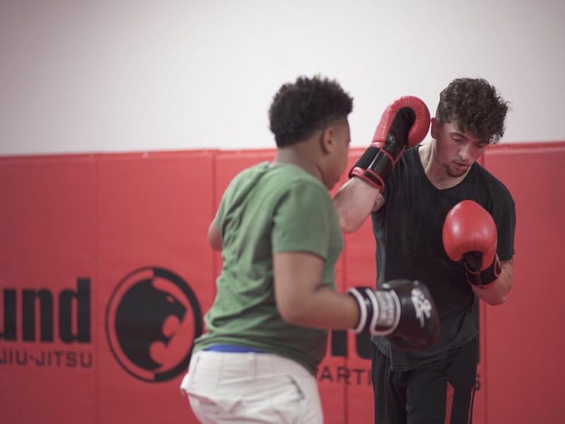 Two martial arts students sparring with punching gloves